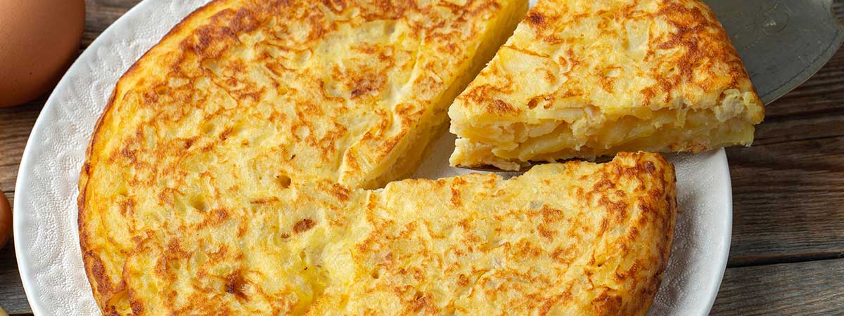 Tortilla de patatas con gambones y queso crujiente